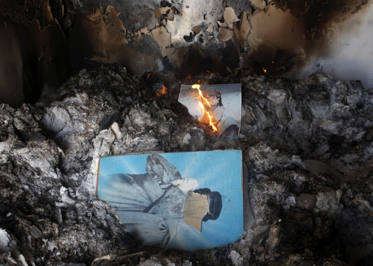 People burn pictures of Libyan leader Gaddafi inside the main prison of Gaddafi's forces in Benghazi