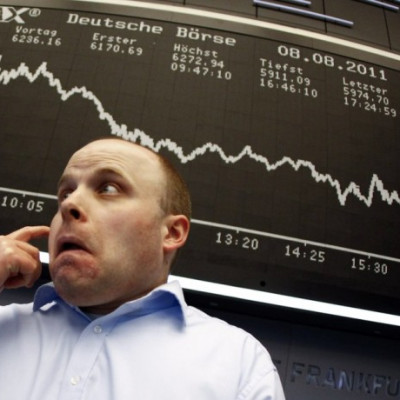 A trader reacts in front of the DAX index board at Frankfurt's stock exchange