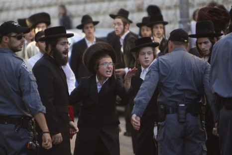 Ultra-Orthodox Jews shout at a policeman during a protest against the opening of a road on the Sabbath