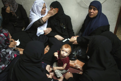 The daughter of a Hamas gunman sits near her crying mother during funeral in northern Gaza