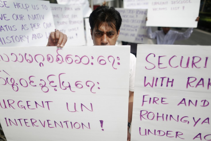 Men hold banners as they protest in front of the U.S. embassy in Bangkok