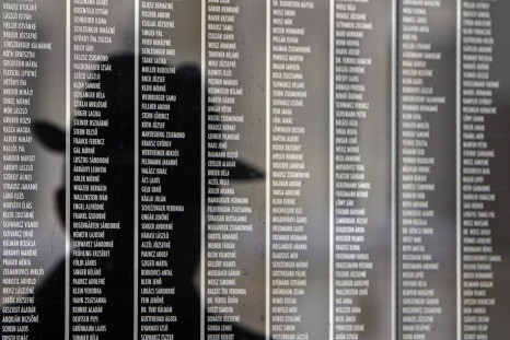Hungarian man is reflected on a wall containing the names of victims at Budapest's Holocaust Memorial Centre