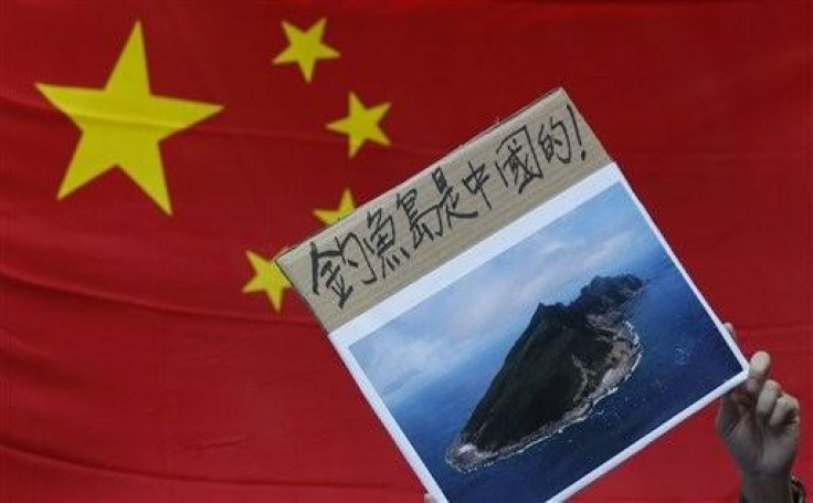 A protester holds a photo of the disputed Senkaku or Diaoyu islands (Photo: Reuters)