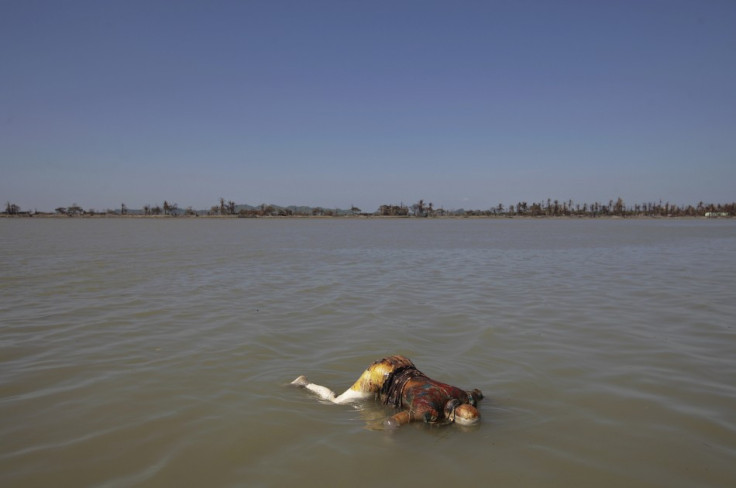 A dead body floats in the sea near the part of Pauktaw township that was burned in recent violence