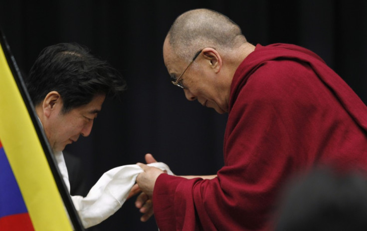 Tibetan spiritual leader the Dalai Lama gives a Tibetan shawl to Japan's main opposition Liberal Democratic Party president Shinzo Abe, at the upper house members' office building in Tokyo