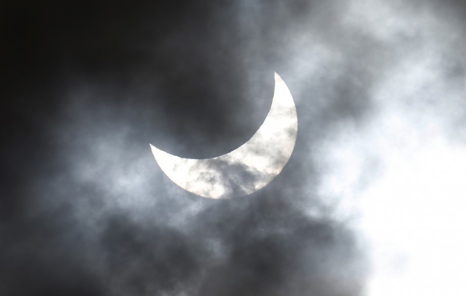 Clouds obscure the moon passing in front of the sun as it approaches a full solar eclipse in the northern Australian city of Cairns