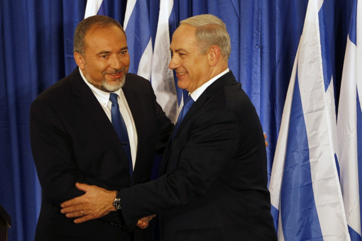Benjamin Netanyahu and Avigdor Lieberman shake hands at a joint news conference in Jerusalem