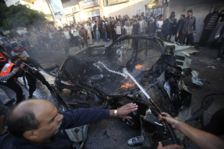 Palestinians extinguish the fire after an Israeli air strike on a car in Gaza City