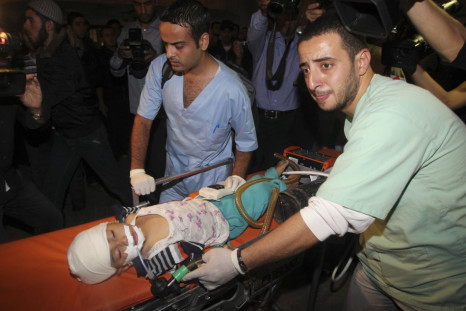 Palestinians wheel a wounded child into a hospital after an Israeli air strike in Gaza City