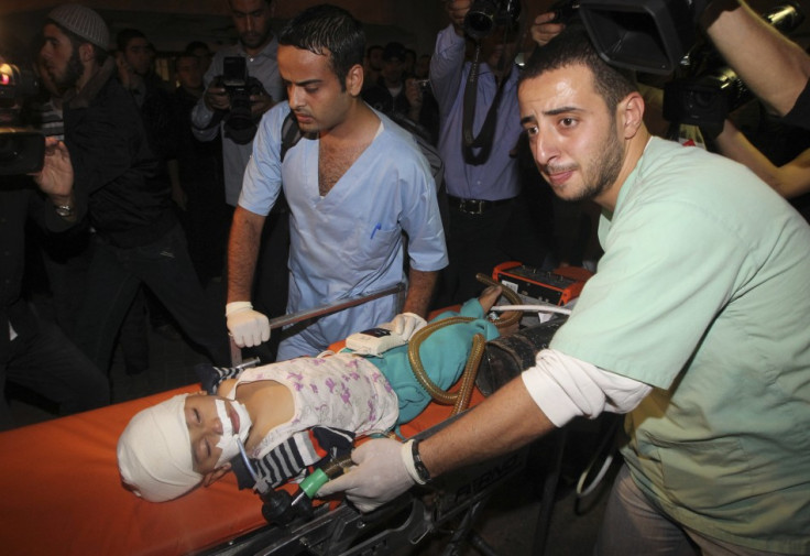 Palestinians wheel a wounded child into a hospital after an Israeli air strike in Gaza City