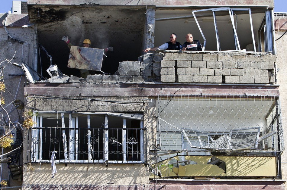 An Israeli soldier throws a blood-stained table out of a building damaged by a rocket, fired from Gaza, An Israeli soldier throws a blood-stained table out of a building damaged by a rocket, fired from Gaza,