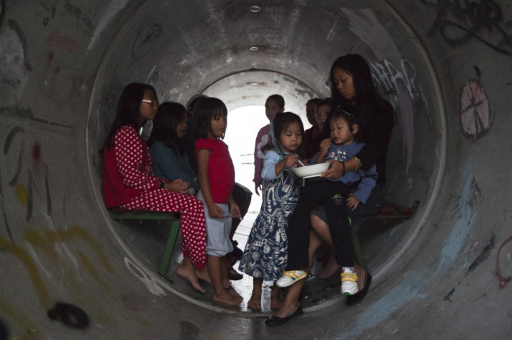 Israelis sit inside a sewage pipe used as shelter during an alert warning of incoming rockets