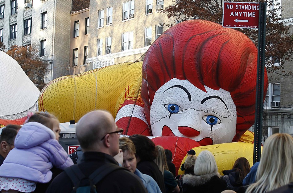 Workers fill a balloon in the shape of Ronald McDonald, with helium, ahead of the Macys Thanksgiving Parade in New York