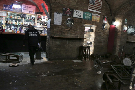A policeman stands in a damaged pub after a fight in downtown Rome