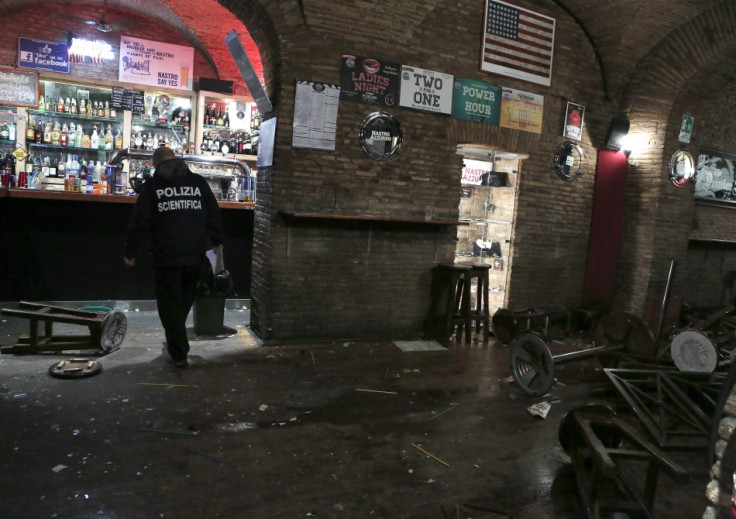 A policeman stands in a damaged pub after a fight in downtown Rome