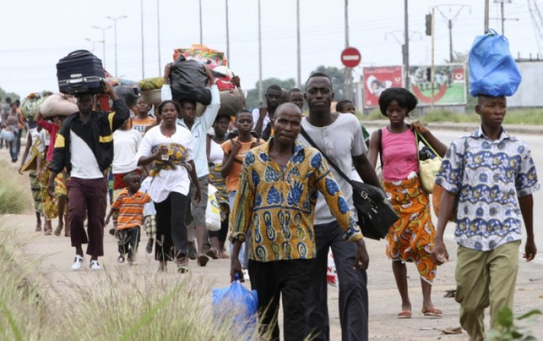 Residents flee with their belongings after clashes between forces loyal to incumbent president Laurent Gbagbo and his rival Alassane Ouattara in Abobo
