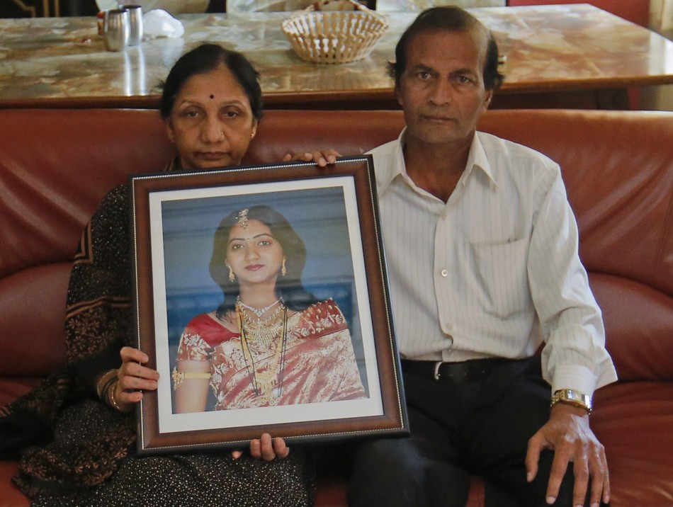 Parents of Savita Halappanavar hold her portrait as they pose for a picture at their house in Belgaum