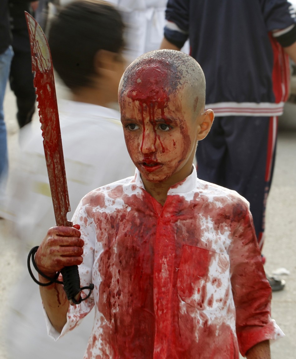 An Iraqi Shiite Muslim child gashes his forehead with a sword