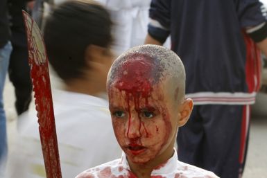 An Iraqi Shi'ite Muslim child gashes his forehead with a sword