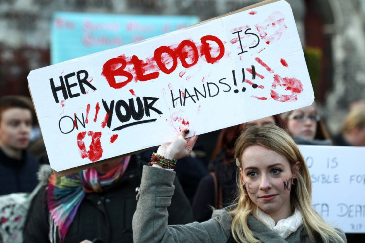 A woman holds a poster during a vigil in Dublin in memory of Savita Halappanavar and in support of changes to abortion law. The 31 year old's family claimed that she died after being repeatedly refused a termination during  miscarriage