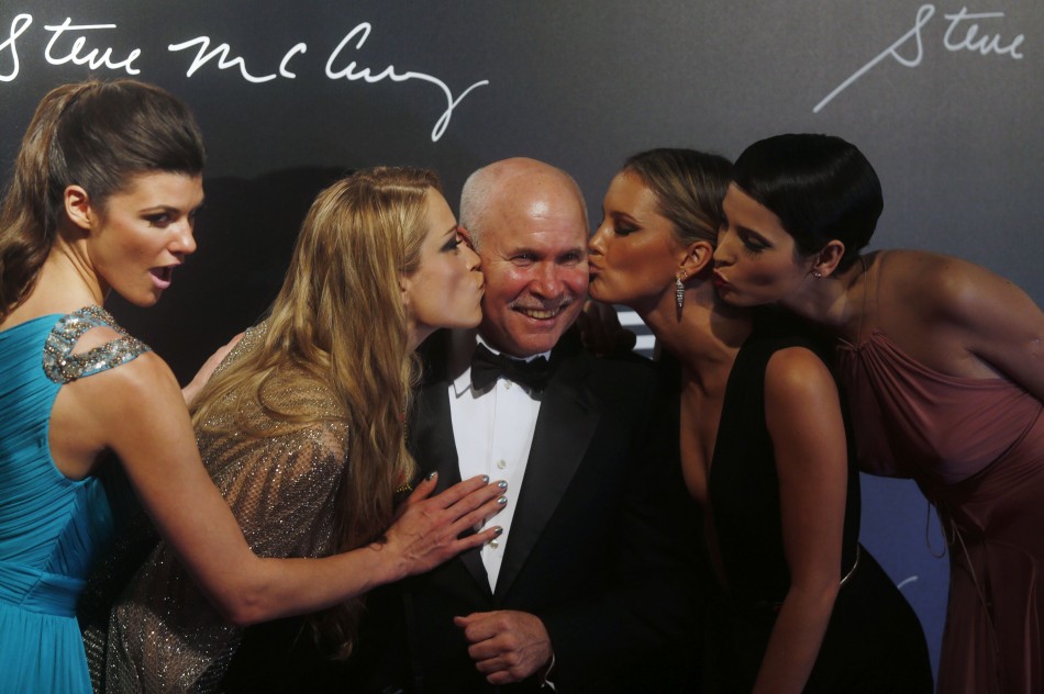 Photographer Steve McCurry poses with models for the launching of the Pirelli Calendar 2013 in Rio de Janeiro