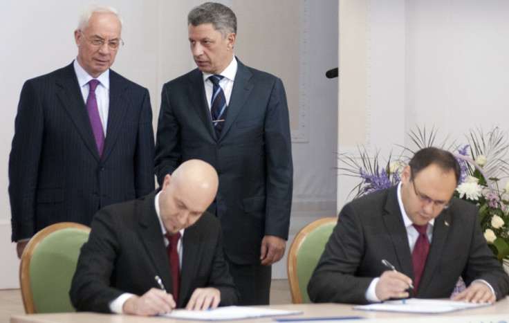 Ukrainian PM Azarov and Energy Minister Boiko talk during signing of an agreement in Kiev (Photo: Reuters)