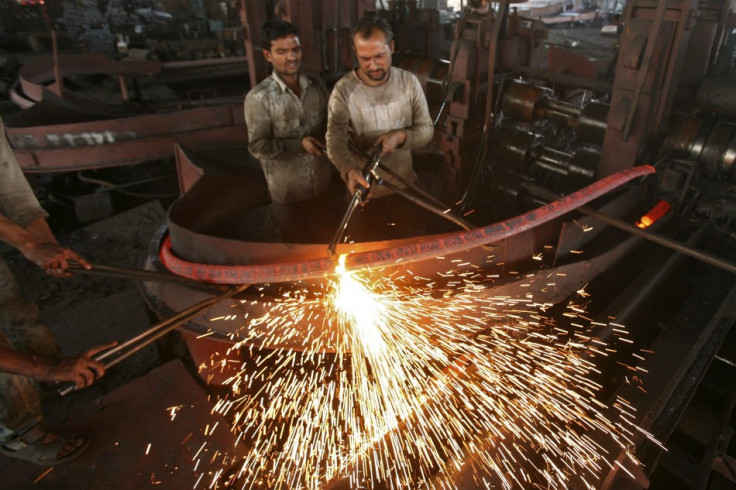 Labourers work inside an iron factory