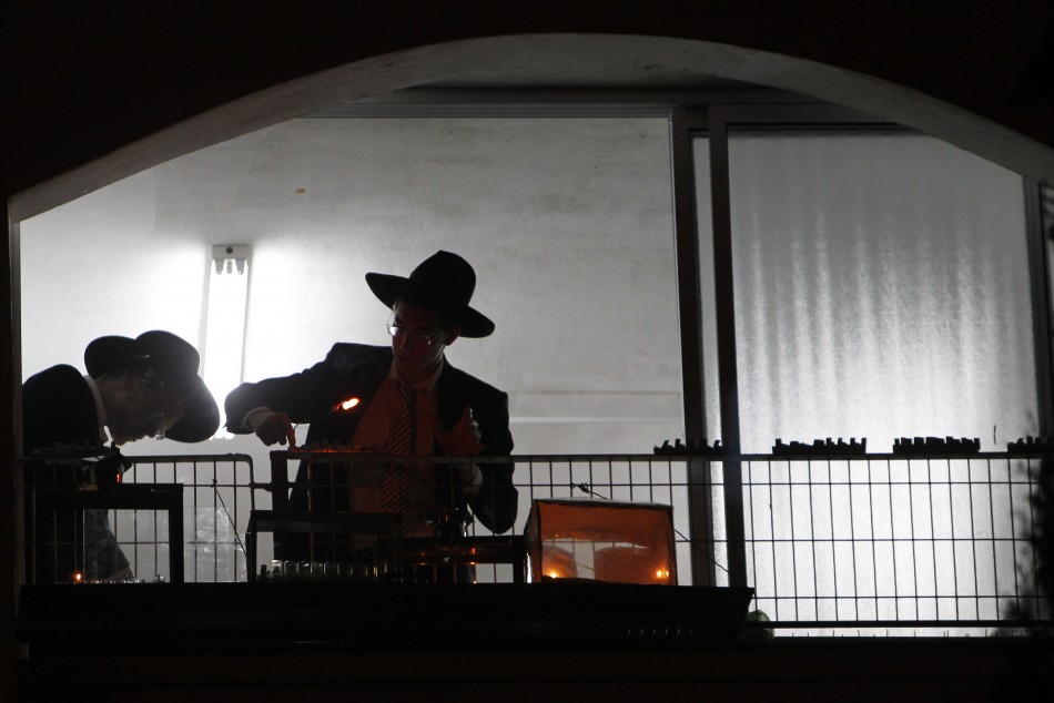 An ultra-Orthodox Jew lights a candle for Hanukkah in Ashdod