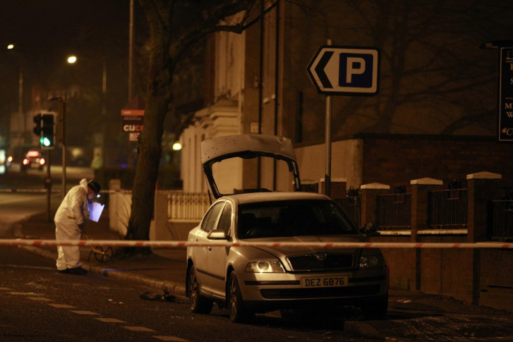 Forensic officers work around a burnt out unmarked police car in East Belfast (Reuters)