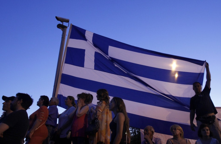 Supporters of the extreme right Golden Dawn party stand below a Greek flag as they attend a pre-election rally in Athens