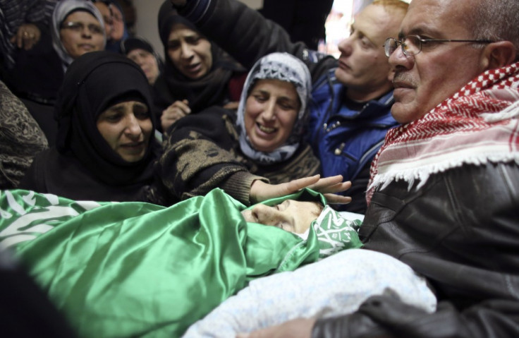 Relatives of Palestinian teenager Salaymeh mourn during his funeral in Hebron