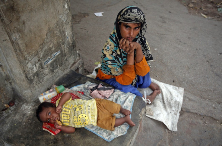 Polio patient Rukhsana, 32, begs with her eight-month old boy Waheed outside a mosque in Karachi