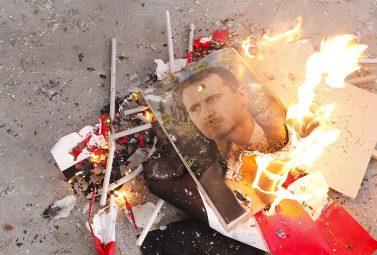 Pictures of Syria's President Bashar al-Assad and Syrian flags burn after being set on fire by Free Syrian Army