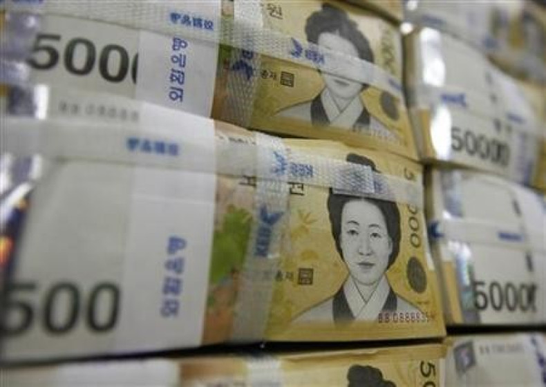 Fifty-thousand-won notes are piled up after being counted at a bank in Seoul