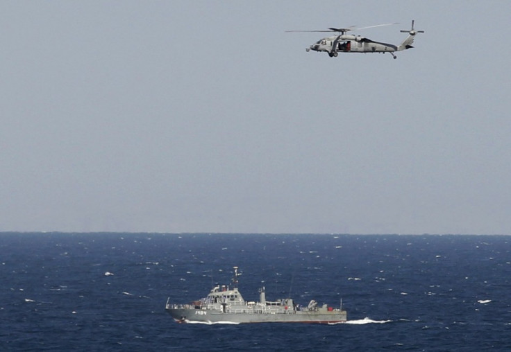 A helicopter from the Nimitz-class aircraft carrier USS Abraham Lincoln hovers over an Iranian patrol ship