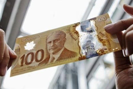 A man holds the new Canadian 100 dollar bill made of polymer in Toronto.