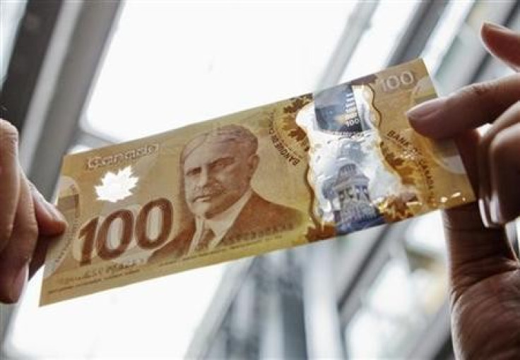 A man holds the new Canadian 100 dollar bill made of polymer in Toronto.