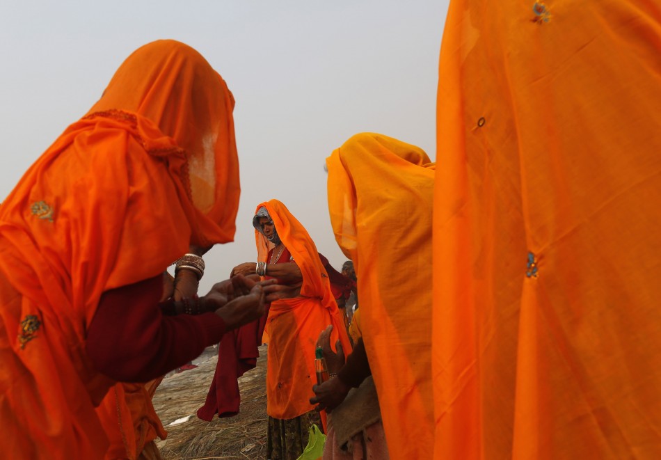 Hindu devotees apply oil on bodies after taking holy dip in river Ganges ahead of Kumbh Mela in Allahabad