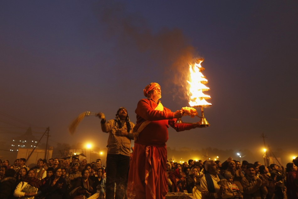 Hindu priest holds oil lamp as performs evening prayers near banks of river Ganges ahead of Kumbh Mela in Allahabad