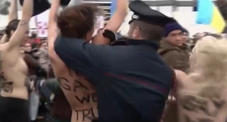 Policeman grabs semi-naked protester