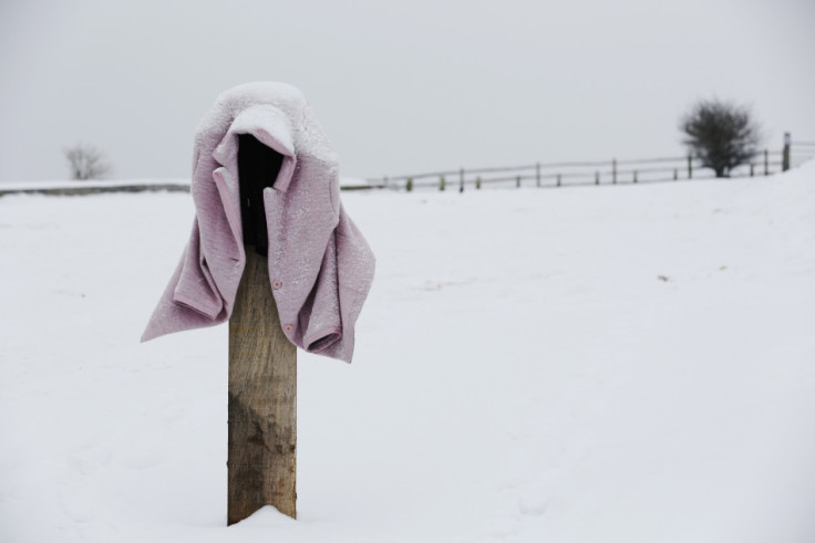 A snow-covered coat is left hanging on a pillar in a car park near Hassocks in south east England