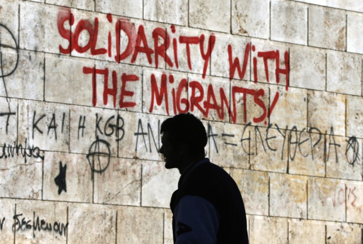 A man walks past graffiti outside the Athens' Academy in central Athens