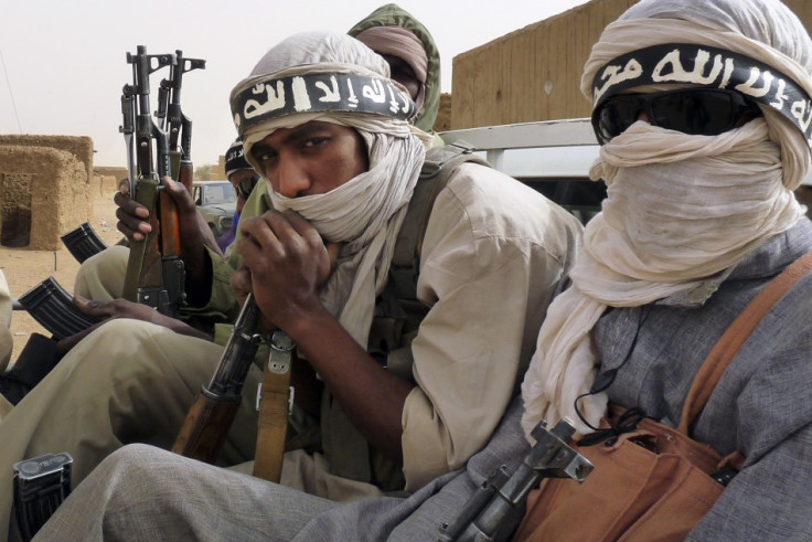 Militiaman from the Ansar Dine Islamic group ride on an armed vehicle in northeastern Mali