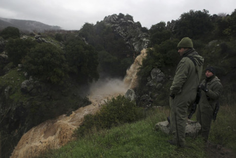 Israeli soldiers look at the Saar waterfall on the slopes of the Golan Heights