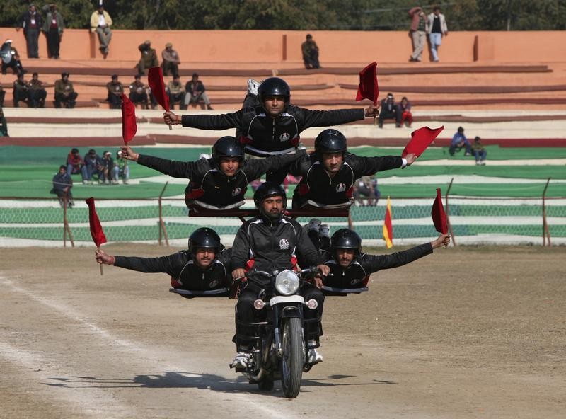 Indian policemen perform a stunt on a motorcycle during the Republic Day parade in Jammu January 26, 2013.