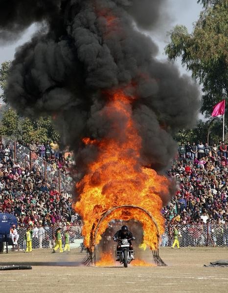An Indian policeman performs a stunt on his motorcycle during the Republic Day parade in Jammu January 26, 2013. India celebrated its 64th Republic Day on Saturday.