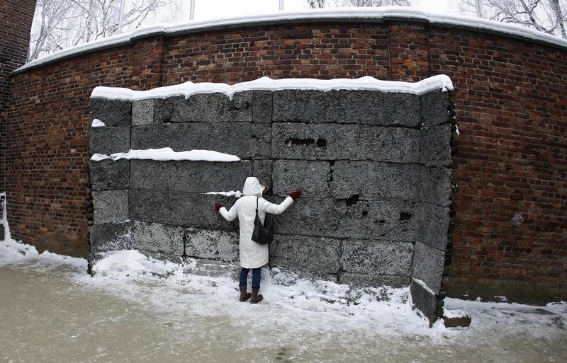 A Japanese visitor touches the death wall at the Auschwitz concentration camp January 27, 2013. A ceremony to mark the 68th anniversary of the liberation of Auschwitz by Soviet troops and to remember the victims of the Holocaust was held in Auschwitz-Birk