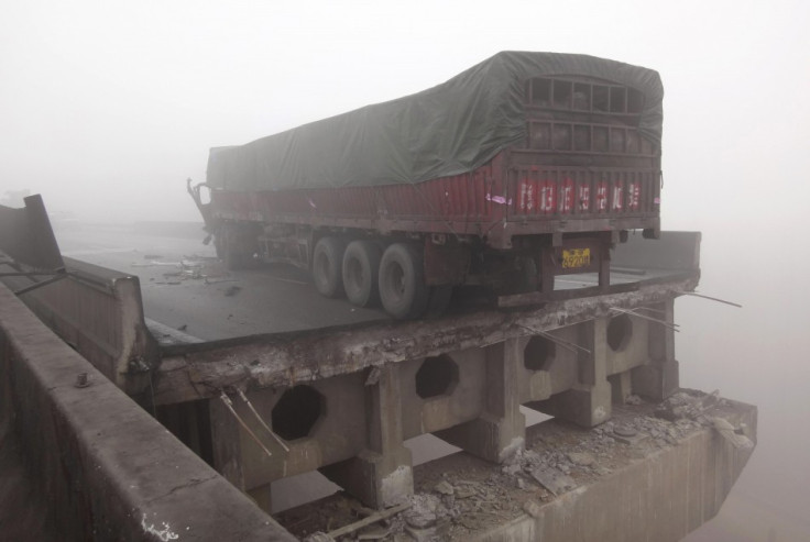 A truck stops near a section of the partially collapsed expressway bridge (Reuters)