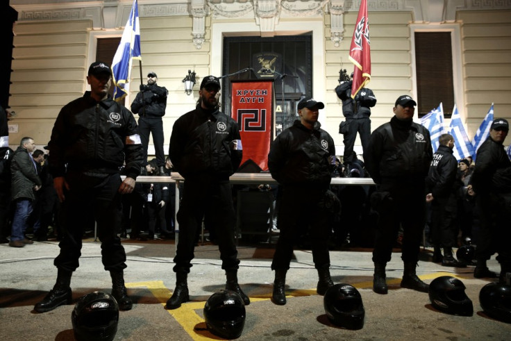 Members of the extreme-right Golden Dawn party stand around a stage during a gathering in Athens