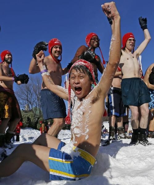 Yohei Oyoshi, a journalist from Japan, reacts after being covered with snow during the snow bath at the Quebec Winter Carnival on the Plains of Abraham in Quebec City, February 16, 2013.